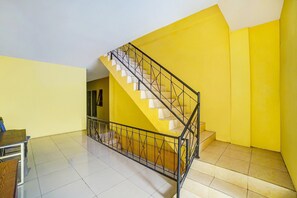 A staircase with a metal railing leading to a landing. - Hotel O Brayan | Cozy Single Room (Medan)
