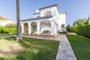 A two-story house with a patio, outdoor seating, and a well-maintained lawn. - A&N Diamante, Valle Niza (Benajarafe)