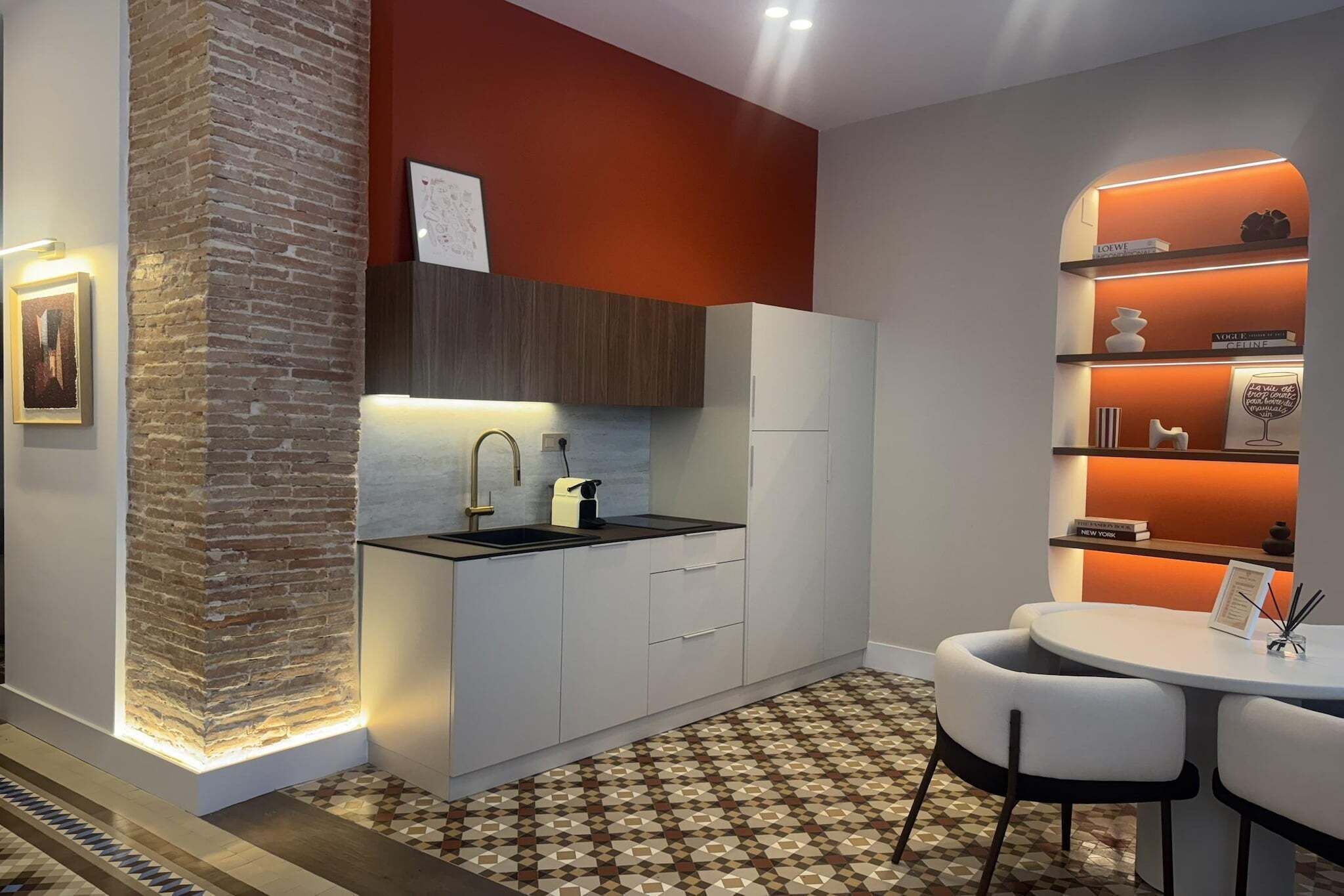 A modern kitchen with a built-in island, white cabinetry, and a patterned floor.