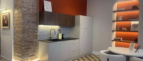 A modern kitchen with a built-in island, white cabinetry, and a patterned floor.