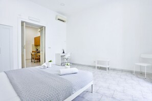 Ein modernes Hotelzimmer mit einem Bett, einem Schreibtisch, einem Stuhl und einem kleinen Tisch.