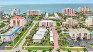 A coastal hotel complex with multiple buildings, a central courtyard, and a view of the ocean. - Oceanside Marco Island Retreat: Expansive Views of Sunset, Pool & Beach (Marco Island)