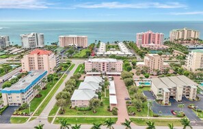 A coastal hotel complex with multiple buildings, a central courtyard, and a view of the ocean. - Oceanside Marco Island Retreat: Expansive Views of Sunset, Pool & Beach (Marco Island)