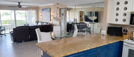 A modern kitchen with blue cabinets, a granite countertop, and a built-in oven.