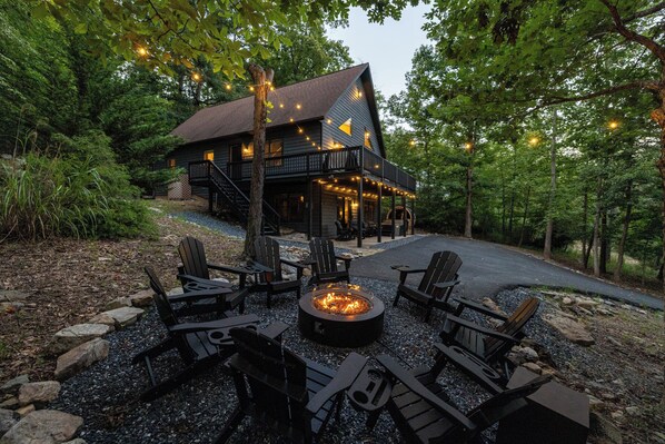 A cabin with a fire pit and outdoor seating.