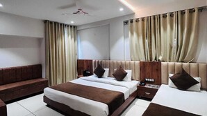 Una habitación de hotel moderna con una cama grande, un sofá, una mesita y un ventilador de techo.