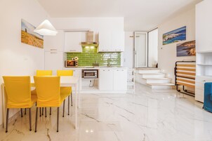 Una cocina moderna con armarios blancos, un salpicadero verde y un horno empotrado.