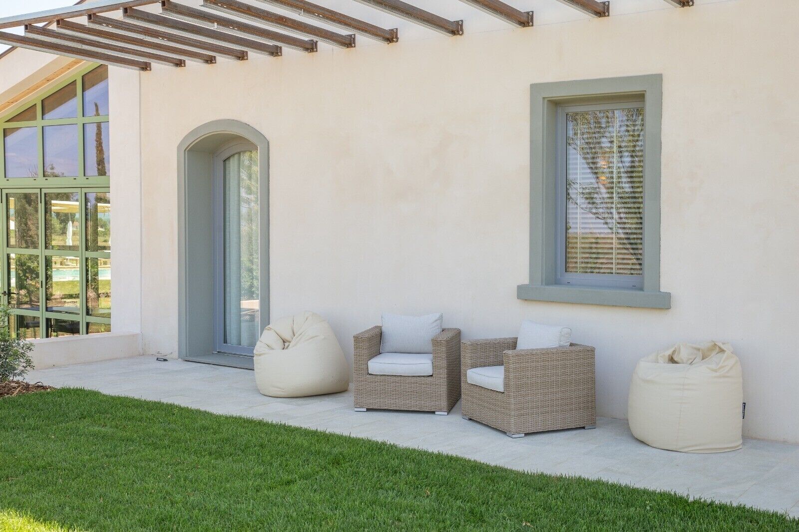 A patio with wicker furniture, a bean bag, and a glass door.