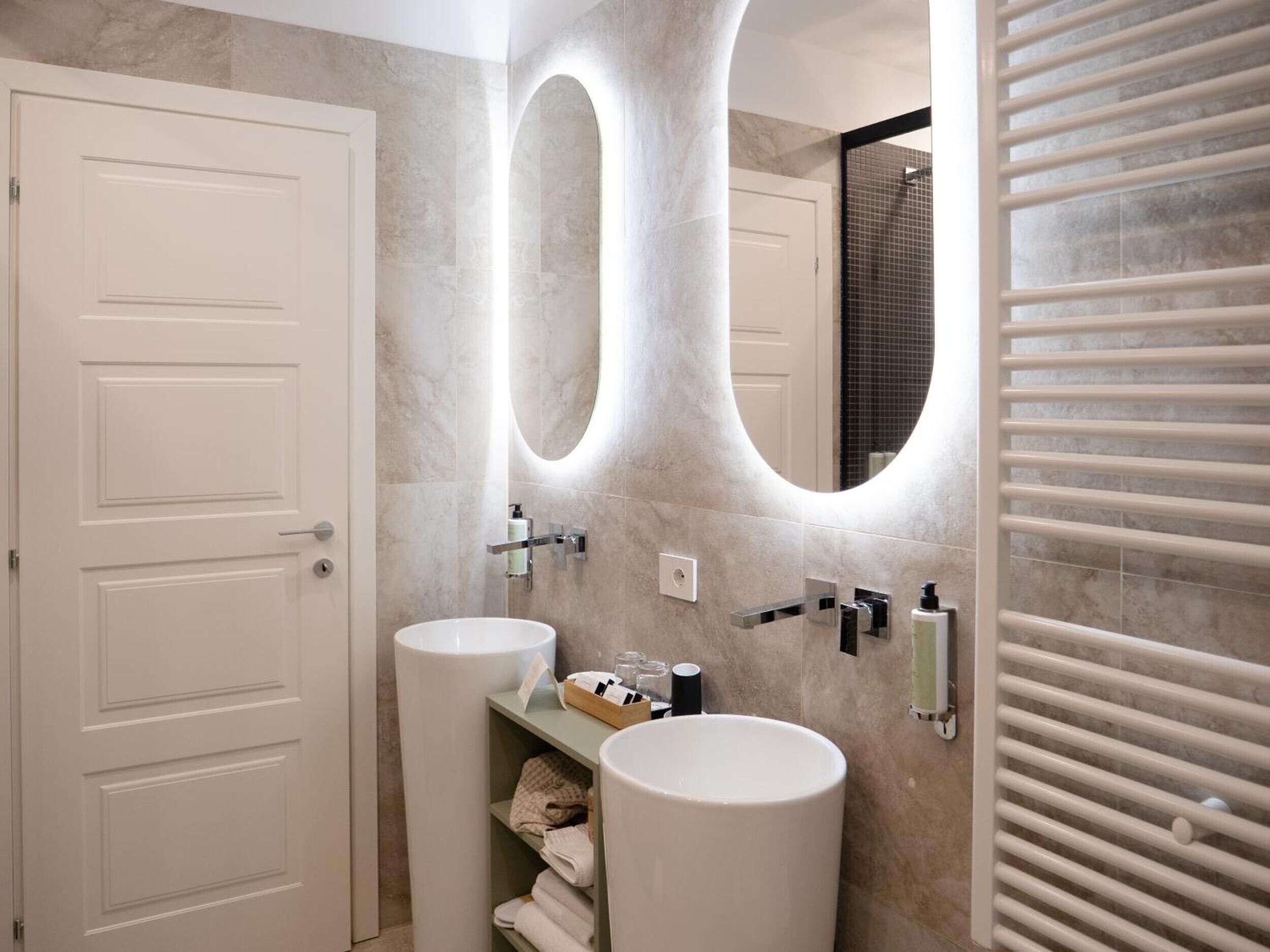 Uma casa de banho moderna com duas pias, um espelho grande e um porta-toalhas.