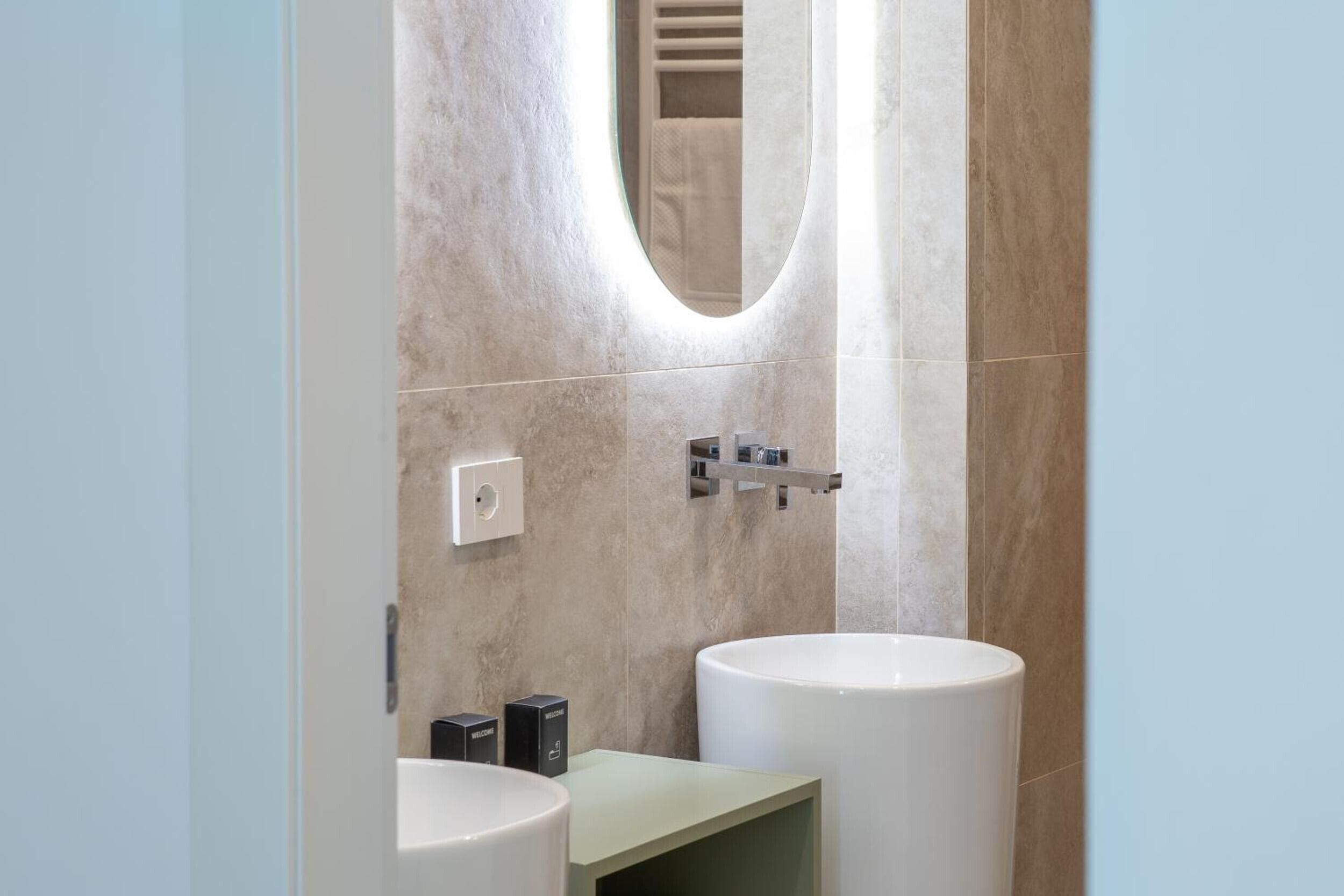 Ein modernes Badezimmer mit zwei Waschbecken, einem Spiegel und einem Handtuchhalter.