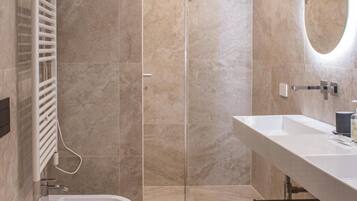 Un bagno moderno con una vasca, un water e un ampio specchio.