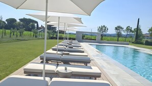 Ein Poolbereich mit Liegestühlen und Sonnenschirmen.