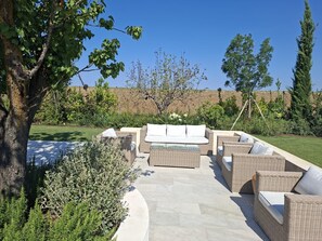 Un patio al aire libre con mobiliario de mimbre y un sendero de piedra.