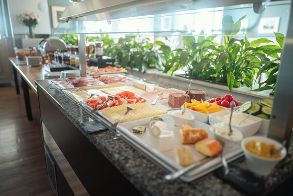 A buffet with various food items and utensils.