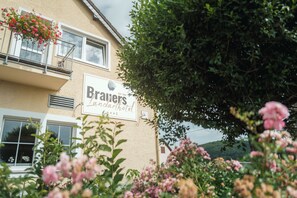 Un edificio con un letrero que dice 'Brav's tandarhotel' y un balcón con flores.