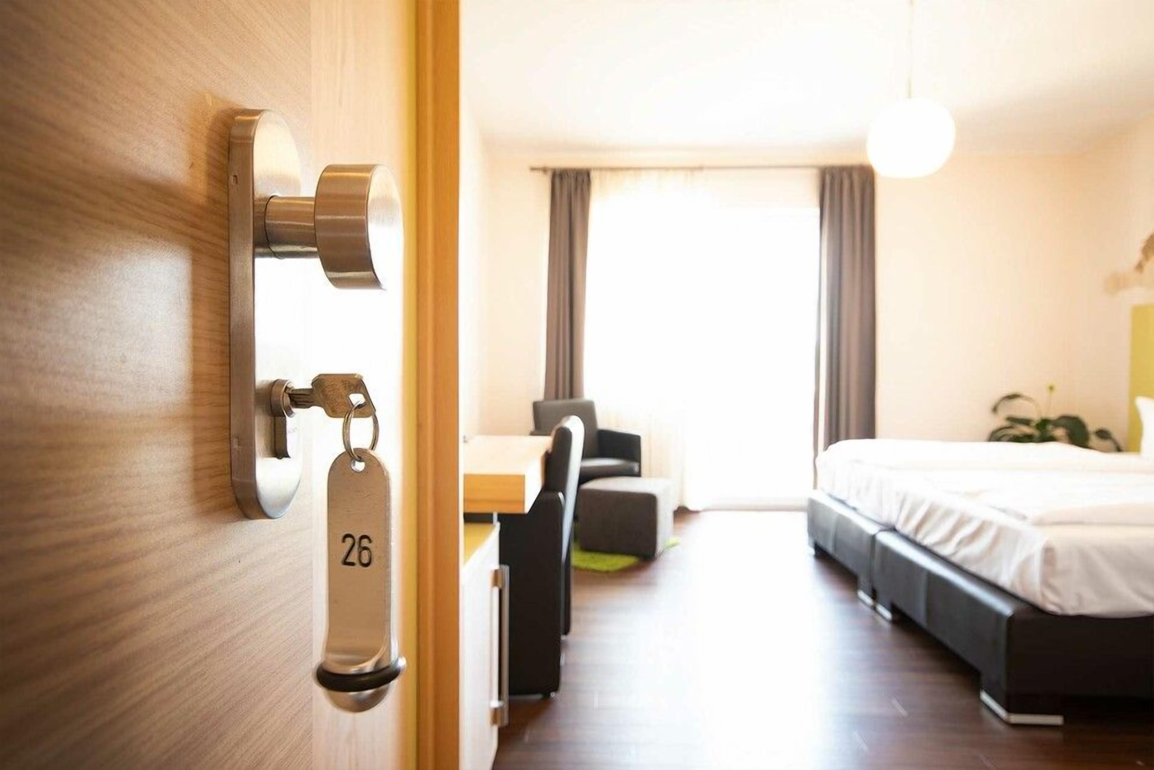 Ett hotellrum med en säng, ett skrivbord och en stol.