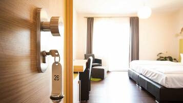 Ett hotellrum med en säng, ett skrivbord och en stol.