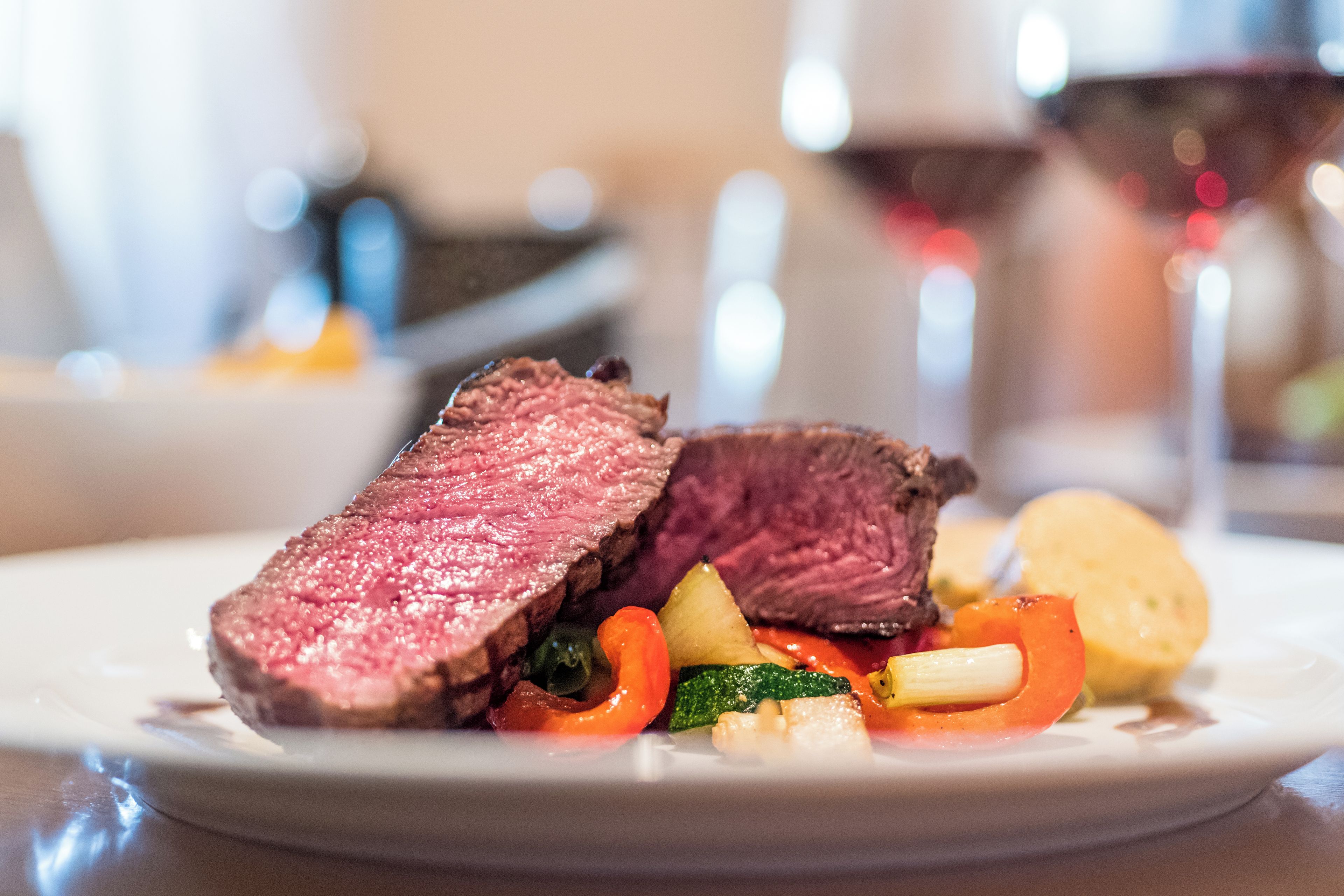 Ein Teller Essen mit geschnittenem Fleisch und Gemüse.