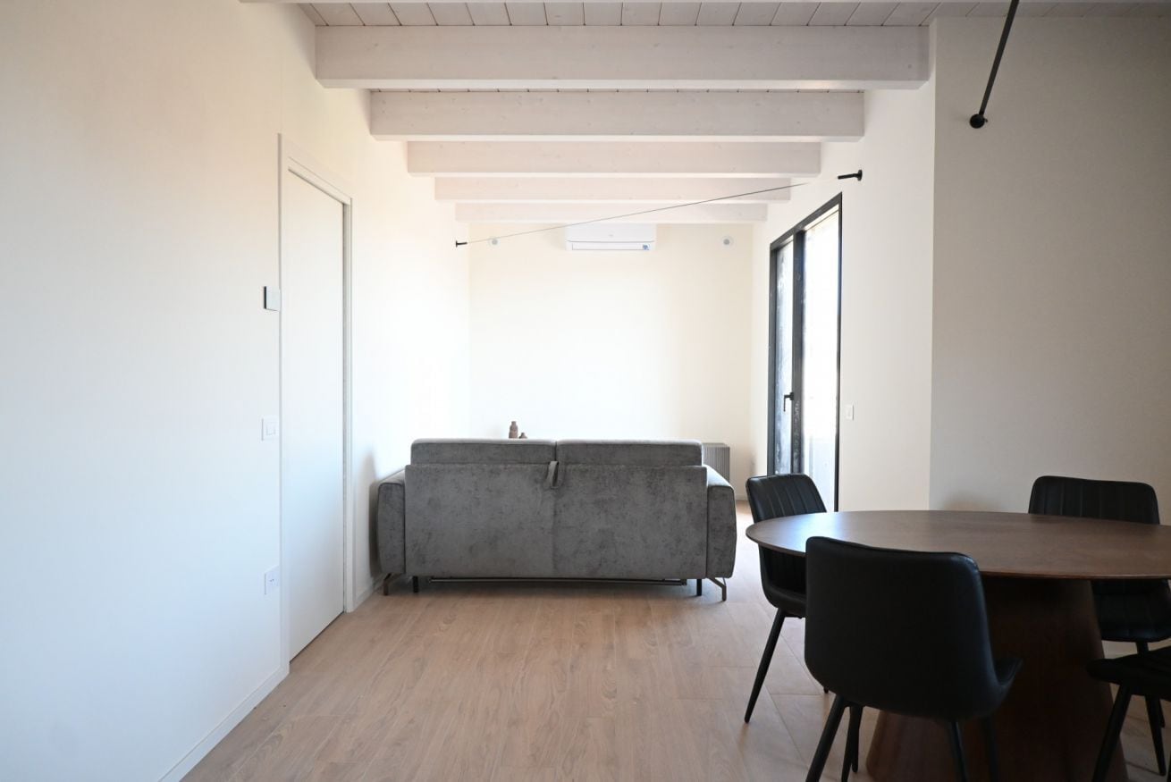 Un interior moderno con sofá, sillas y una mesa de comedor.