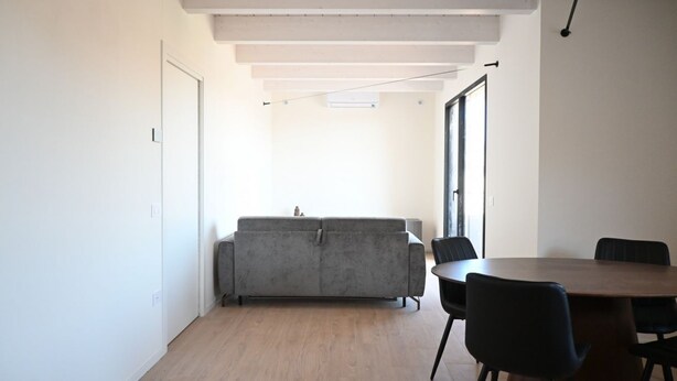 Um interior moderno com um sofá, cadeiras e uma mesa de jantar.