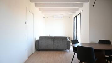 Un interior moderno con sofá, sillas y una mesa de comedor.