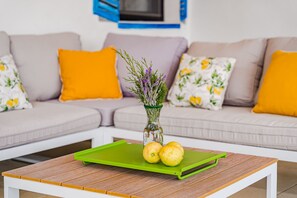 A living room with a wooden coffee table, a vase with flowers, and lemons on a green tray. - Perfect for your vacation (La Vega)