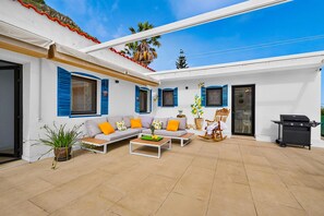 A covered outdoor living area with a sofa set, a dining table, and a barbecue grill. - Perfect for your vacation (La Vega)