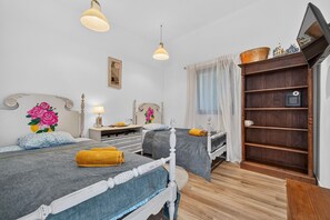 Une chambre d’hôtel avec deux lits, une armoire en bois, un bureau et un miroir.