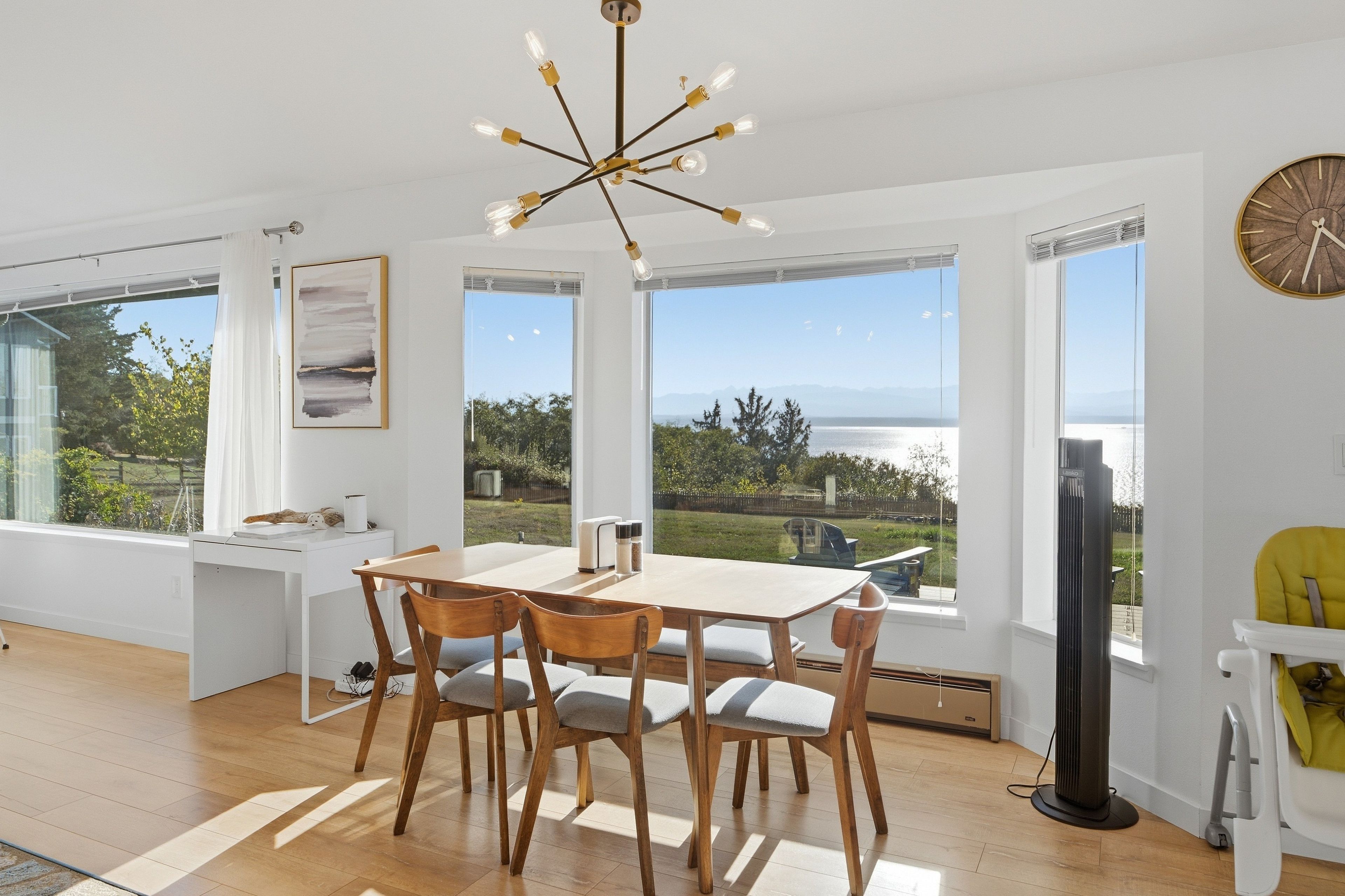 Une cuisine moderne avec une table à manger, des chaises et une vue sur l’extérieur.