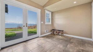 Una habitación con vista al mar, un banco y una puerta que da al exterior.