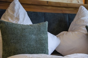 A bed with pillows, a dark headboard, and a wooden headboard. - Chalet Suite "Joy of Life" (Berchtesgaden)