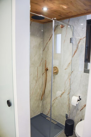 A modern bathroom with a glass-enclosed shower, marble walls, a toilet, and a sink. - Chalet Suite "Joy of Life" (Berchtesgaden)
