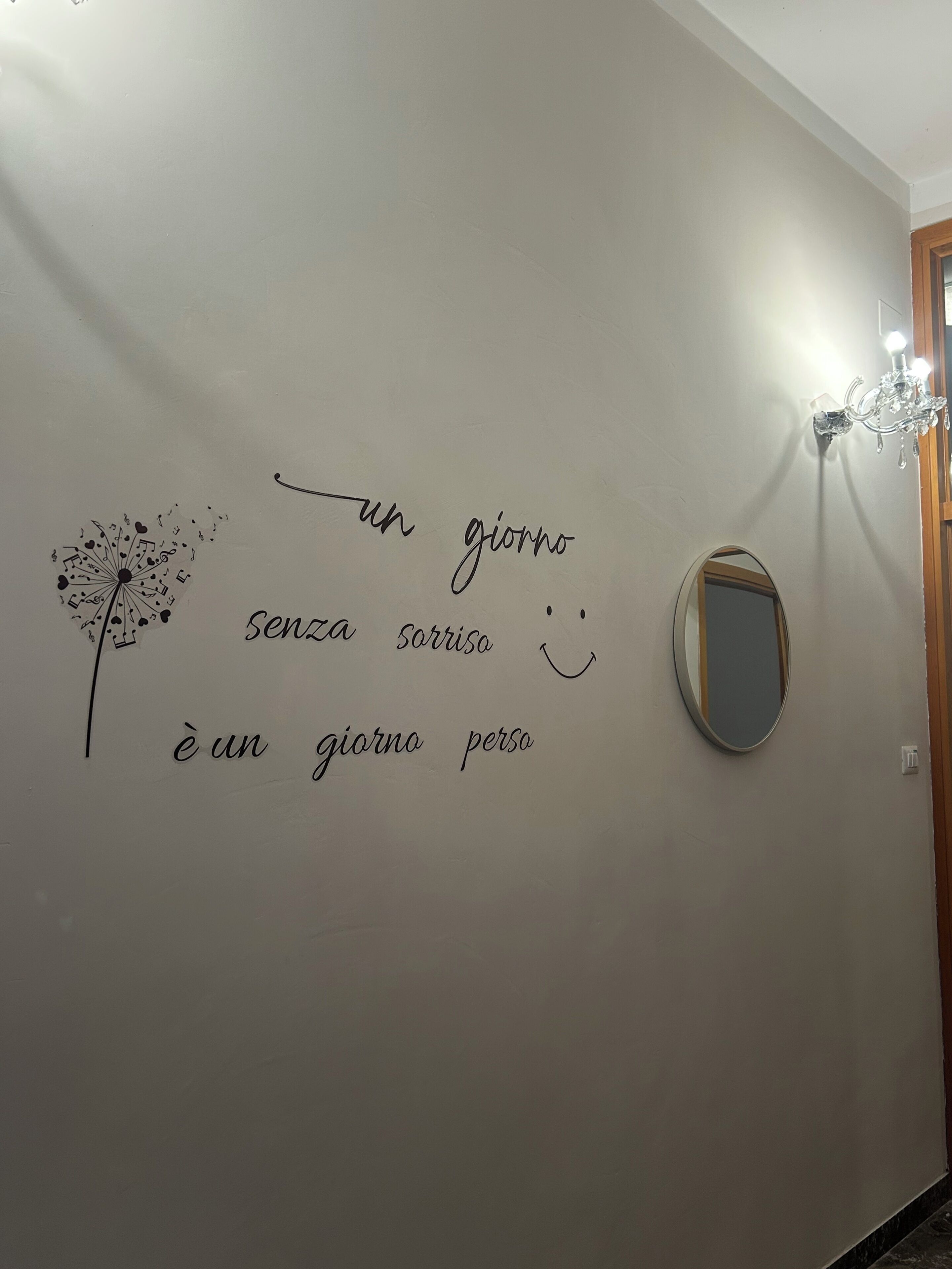 A wall with a dandelion illustration and a mirror.