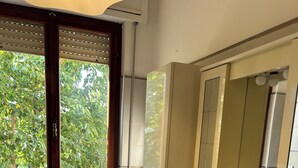 Un baño con inodoro, lavamanos y ventana con persianas.