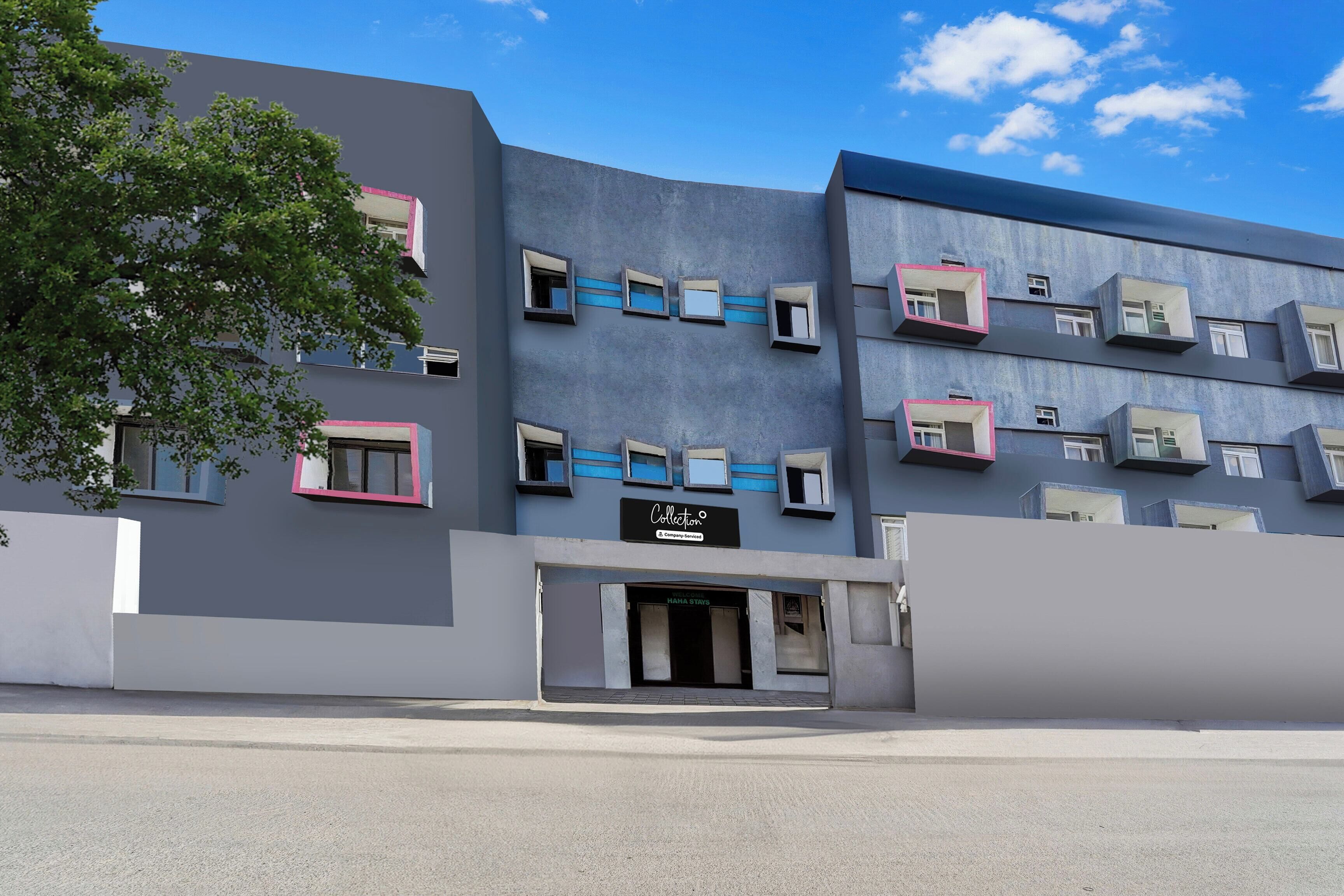 Un edificio moderno con varios balcones, fachada plana y cielo despejado.