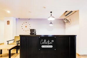 A reception desk with a sign reading 'Collector' and a 'Company-Serviced' label.