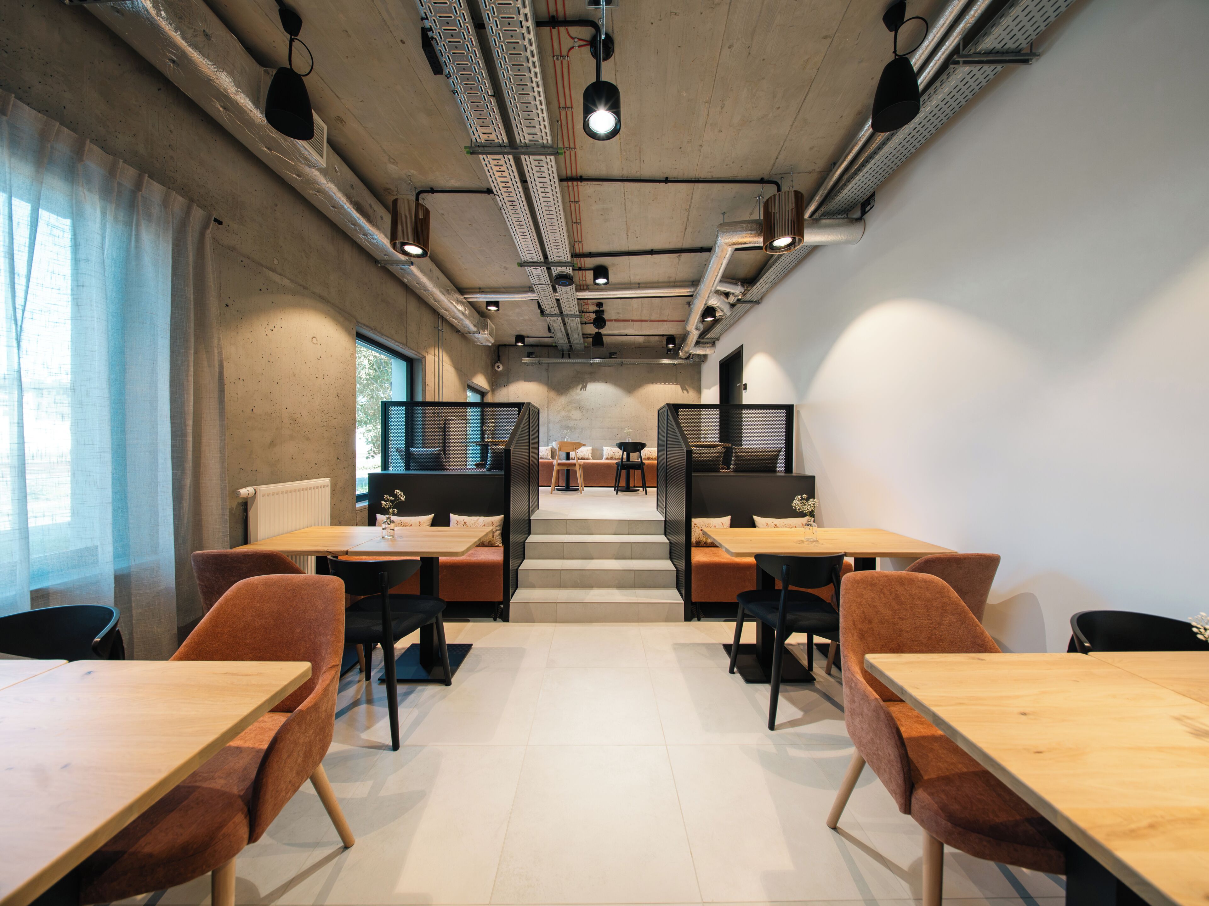Um interior moderno com uma mesa comprida e cadeiras, uma escada e um painel com assentos.