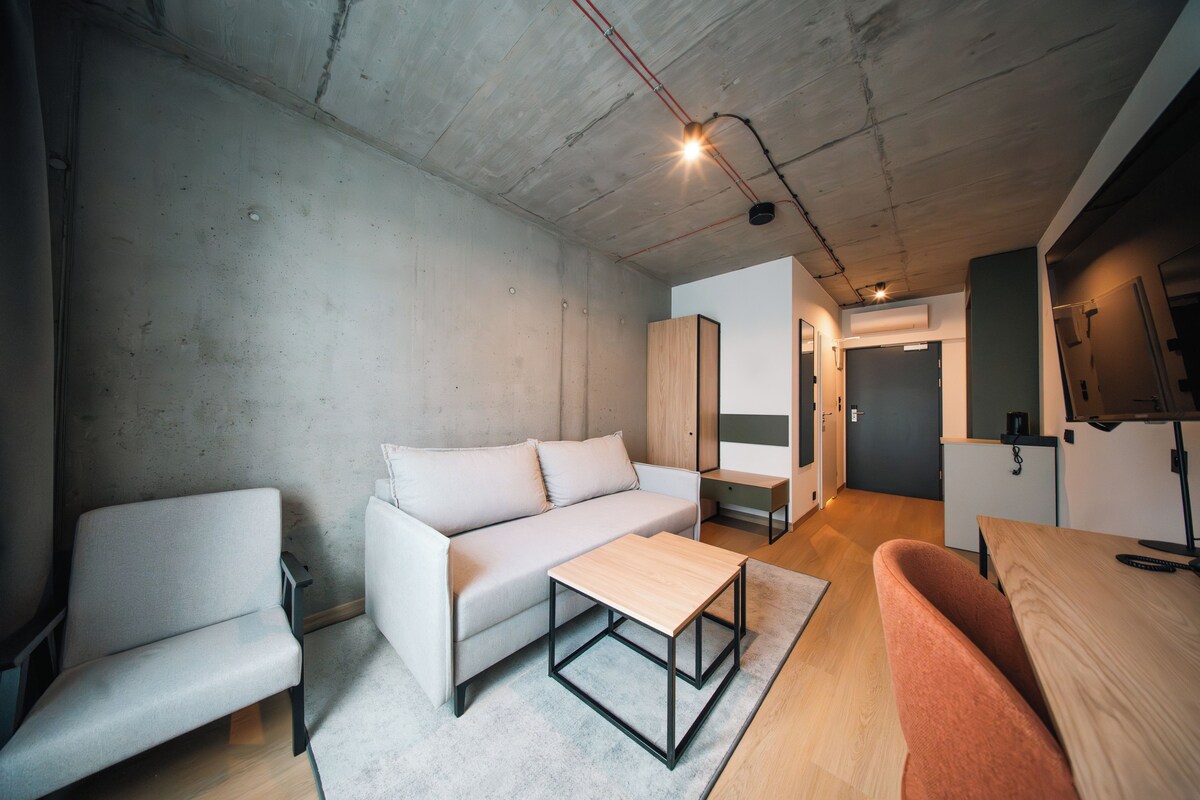 Uma sala de estar moderna com sofá, poltrona e mesa de centro.