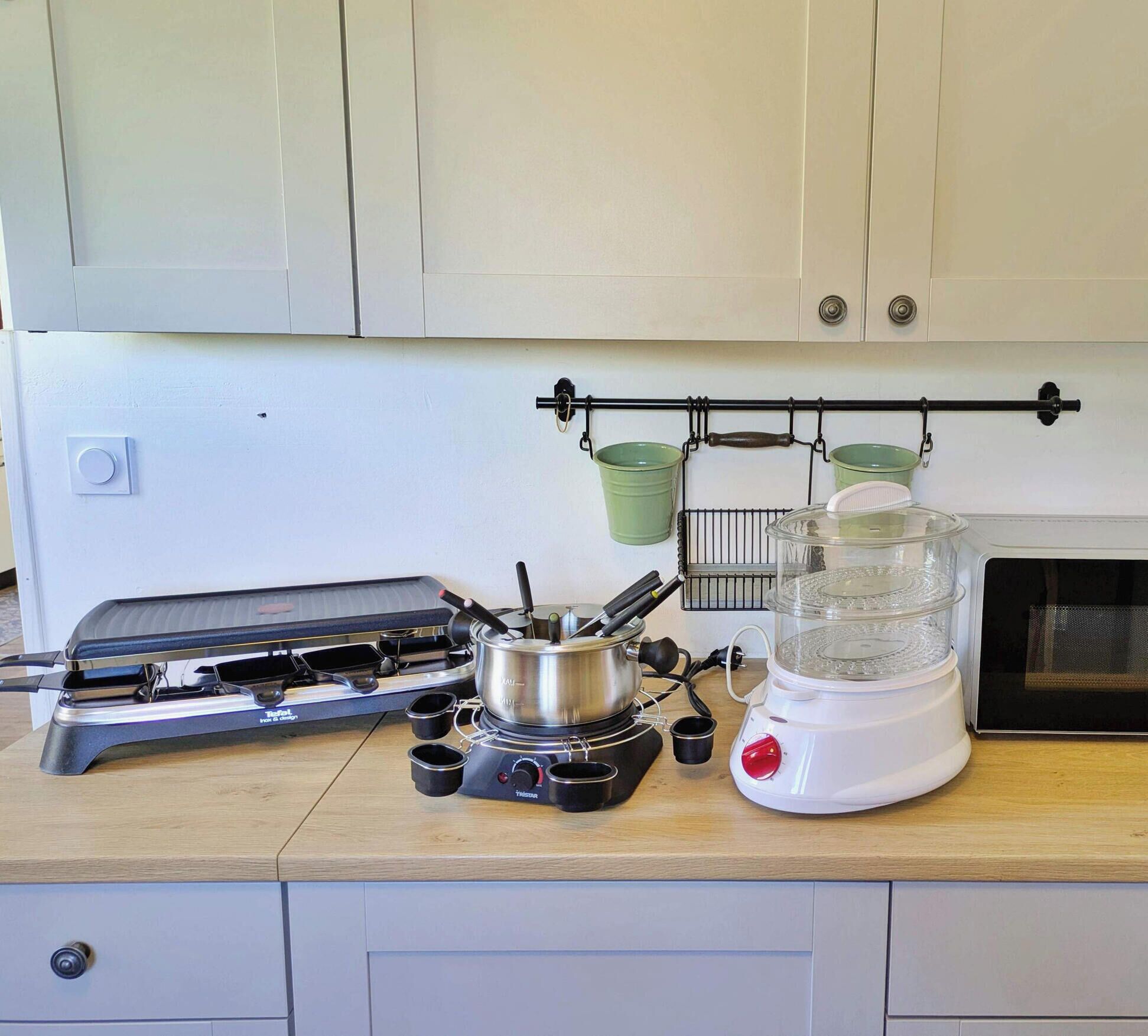 Een keuken met een gasfornuis, een blender en een magnetron.