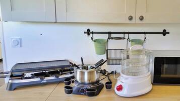 Een keuken met een gasfornuis, een blender en een magnetron.