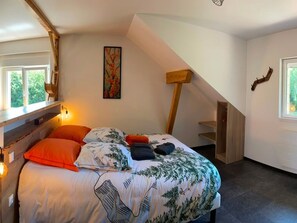 A bedroom with a bed, a painting, a wooden staircase, and a window. - Bright apartment on the forest edge - 2 guests (Hadol)