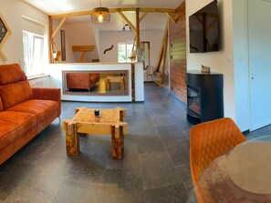 Ein modernes Wohnzimmer mit einer Couch, einem Holztisch und einem Kamin.