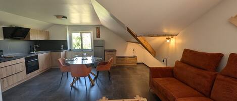 Un appartement moderne de style « loft » comprenant une cuisine, un coin repas et un espace de vie.