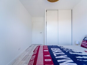 Ein Schlafzimmer mit einem Bett, einer Tür und einer Wandlampe.