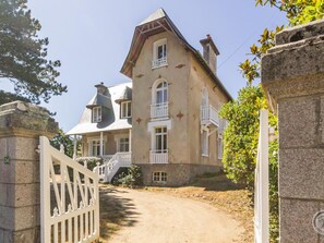 A large, two-story building with a stone facade, multiple windows, and a gated entrance. - Renovated villa with garden - 15 guests (Jullouville)
