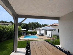 A covered outdoor area with a pool, lounge chairs, and umbrellas. - Villa with pool, WiFi - 10 guests (Moliets-et-Maa)