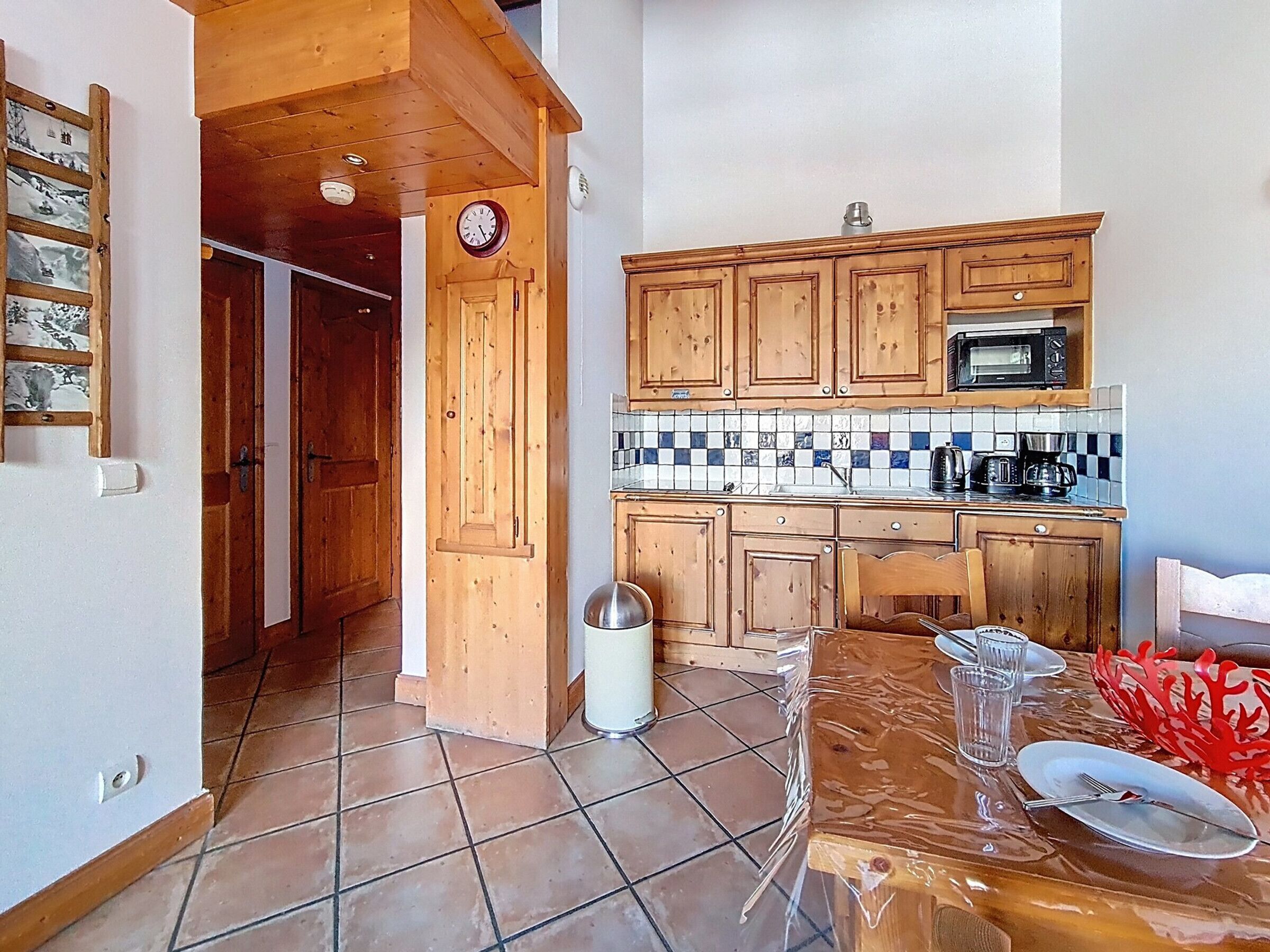 A kitchen with wooden cabinets, a microwave, and a tiled backsplash.