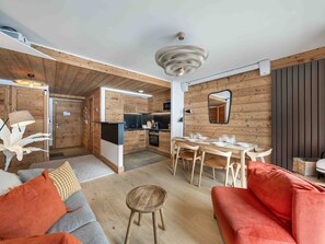 A modern interior with a dining area, kitchen, and seating space. - Family apartment, ideal location - 4 guests (Méribel)