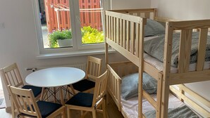 A room with a bunk bed, a round table, and chairs. - 4-person Room With Kitchenette, Sarbinowo (Mielno)