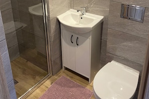 Ein Badezimmer mit Duschkabine, Waschbecken und Toilette.